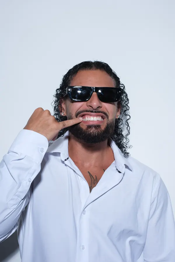Party DJ Ajay Ramos grinning in sunglasses