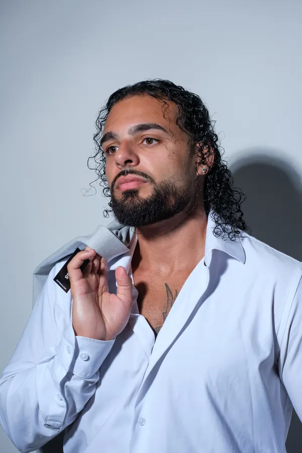 Ajay in a white shirt, looking off camera