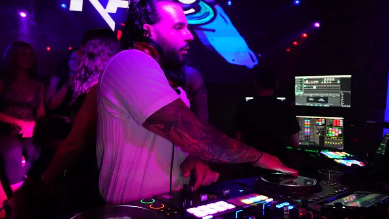 Ajay DJing under pink light