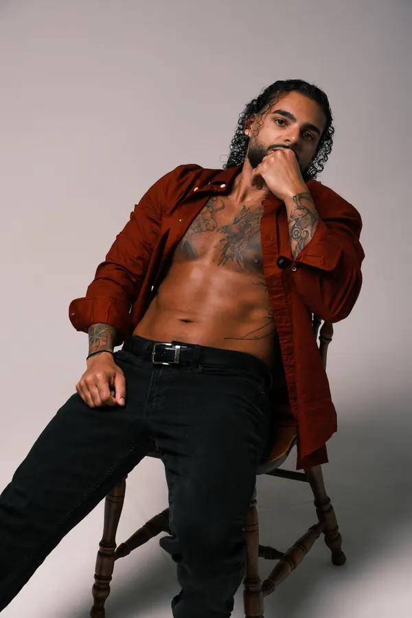 Ajay in an open rust shirt, studio portrait