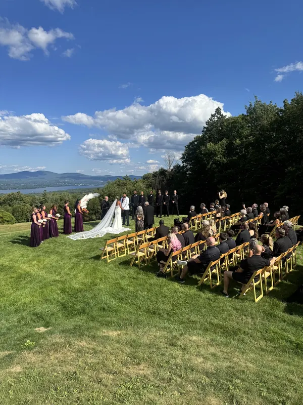 A hilltop wedding ceremony with mountains behind